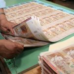 أوراق نقدية موضوعة على مكتب بنكي ترمز إلى الودائع البنكية والسيولة المالية داخل النظام المصرفي بالمغرب.