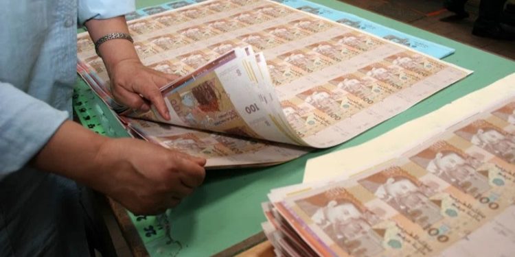 أوراق نقدية موضوعة على مكتب بنكي ترمز إلى الودائع البنكية والسيولة المالية داخل النظام المصرفي بالمغرب.